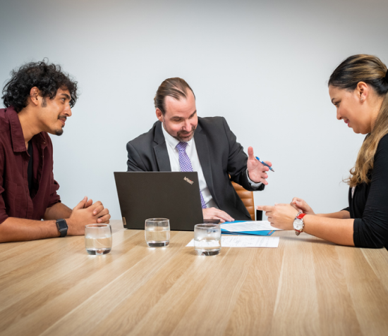 Gnech and Associates lawyer meeting with clients in a Brisbane boardroom